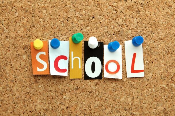 Prikbord met daarop de papieren letters voor 'school' geprikt.