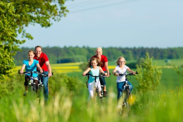 Ouders en kinderen fietsen samen door de natuuur