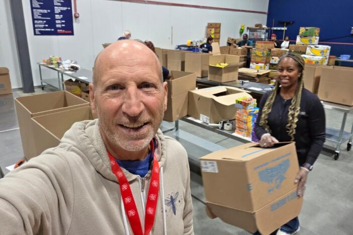 Selfie van man die vrijwilligerswerk aan het doen is n een magazijn.