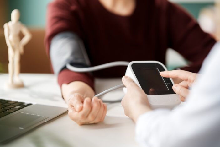 Vrouw laat haar bloeddruk meten.