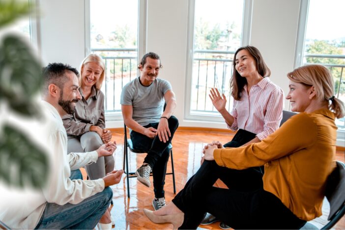 Vijf mensen gaan in gesprek met elkaar.