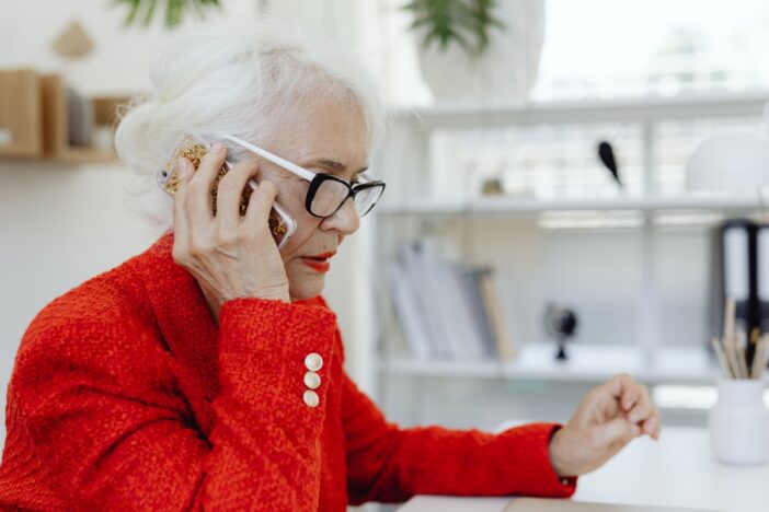 Oudere vrouw belt met smartphone.