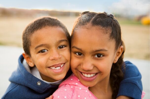 Broer en zus knuffelen elkaar.