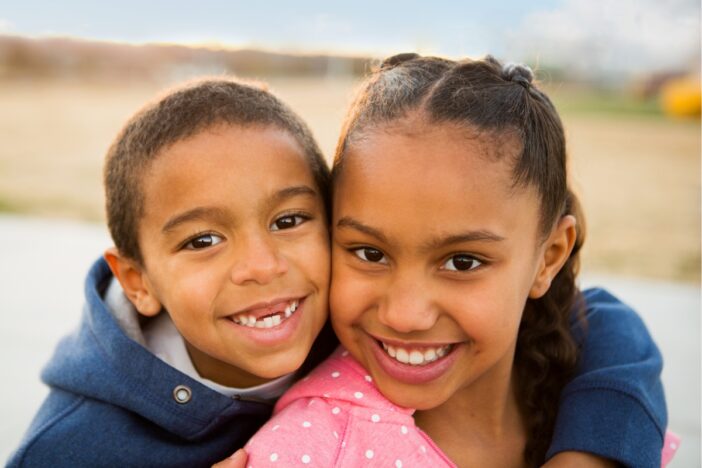 Broer en zus knuffelen elkaar.