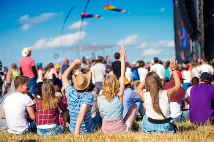 Groep mensen geniet met mooi weer van een festival.
