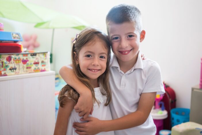 Jongen omhelst zijn zusje.