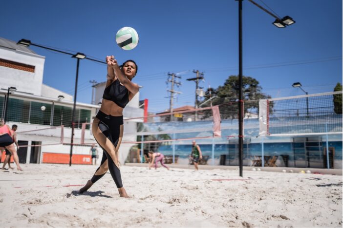 Vrouw speelt beachvolleybal.