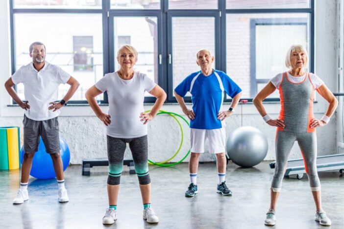 Senioren in een gymzaal met sportkleding.