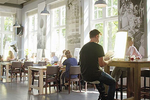 Man in café achter lichtbakl
