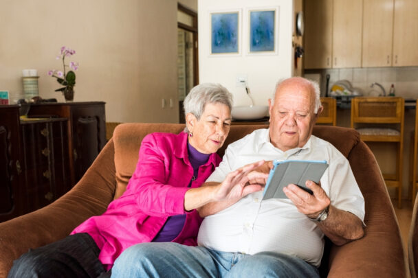 Oudere man en vrouw gebruiken samen een tablet.