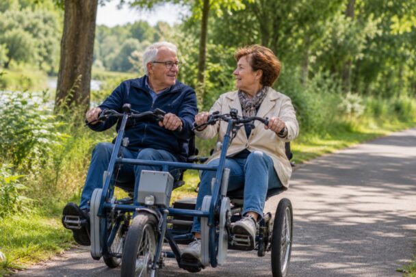 Man en vrouw zitten samen op duofiets in een groene omgeving.